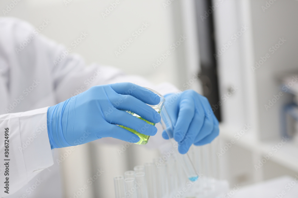 A male chemist holds test tube of glass A male chemist holds test tube of glass
