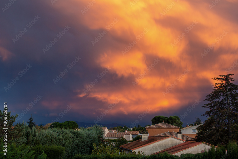 Amazing composition of orange clouds over a village