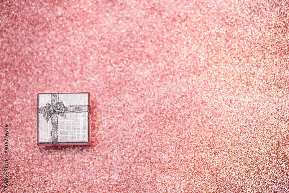 Fototapeta premium Silver gift box on the pink glitter sparkling background