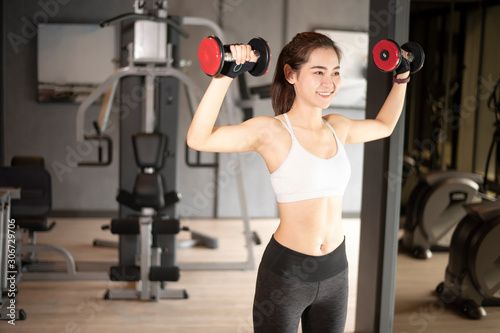 Beautiful asian woman is doing exercise in the gym