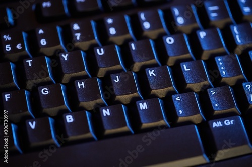 Detail of a black keyboard in blue light