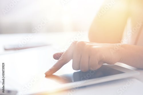 Technology, internet and home concept. Close up faceless portrait of female pointing finger to black blank screen of tablet. Programmer or designer working online and using wireless Internet. © sementsova321