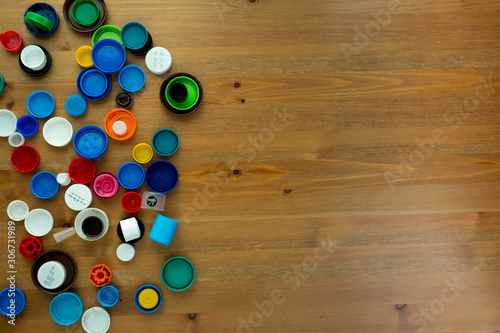  Plastic bottle caps on wooden background. The cover material is recyclable. the concept of environmental protection and ecology