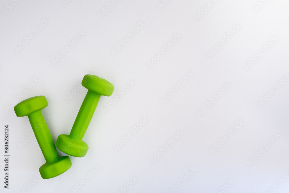 Two green dumbbells isolated on white background Two green dumbbells isolated on white background