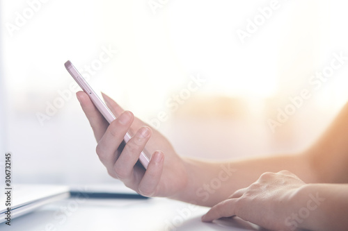 Side view of hand touching phone isolated over white backgrounde  guy sitting at table and holding his modern smart phone for online working  using wireless Internet. Modern technology concept.