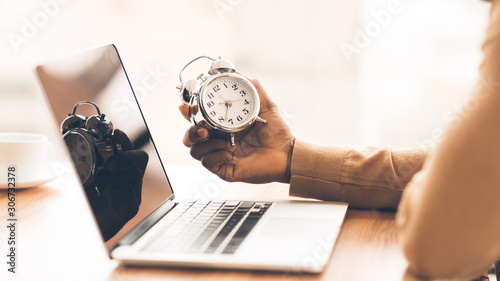 Unrecognizable afro guy checking time on his clock