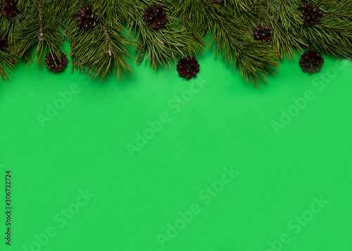 Christmas composition. The border is made of pine branches and cones on a green background. Christmas, winter, New year.