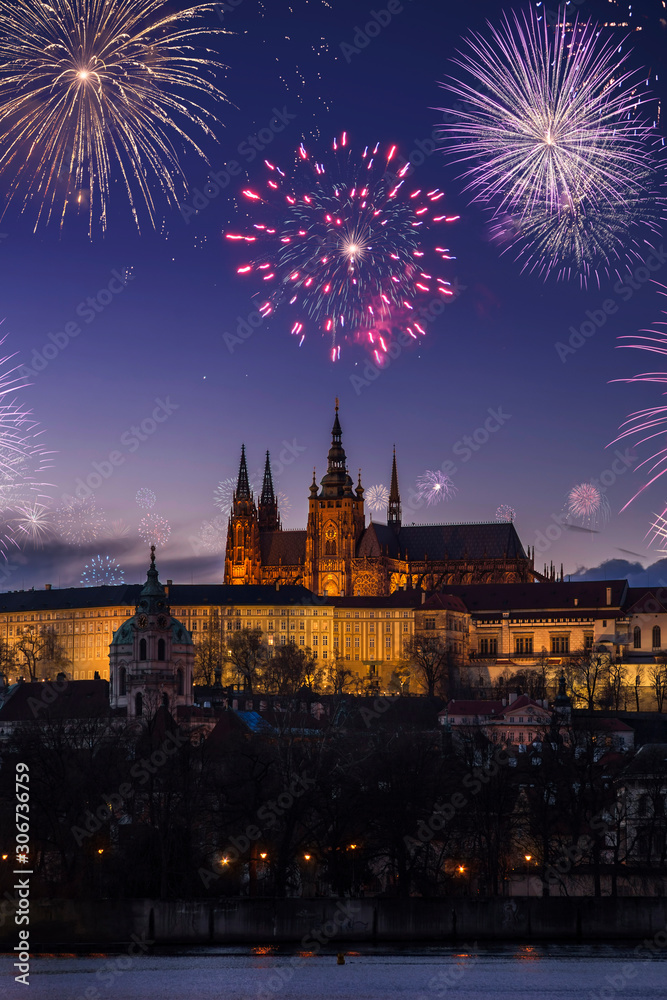 Prague Castle and Cathedral of Saints Vitu with dark night sky and flashing fireworks celebrating New Years