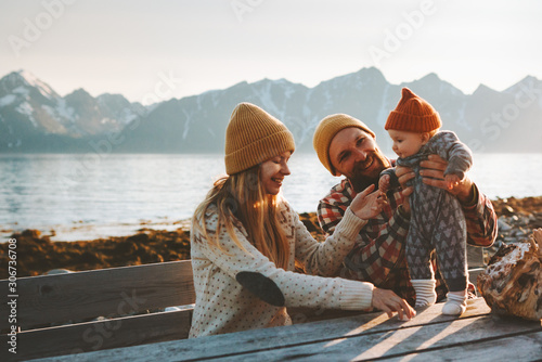 Happy family outdoor mother and father with baby traveling together vacation parents playing with child healthy lifestyle mountains view in Norway
