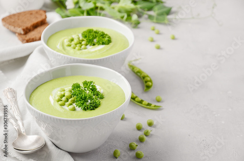Fotografia Green pea soup in bowls on gray concrete or stone background.
