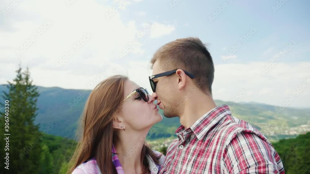 Young active couple taking pictures against the backdrop of a beautiful mountain landscape Young active couple taking pictures against the backdrop of a beautiful mountain landscape