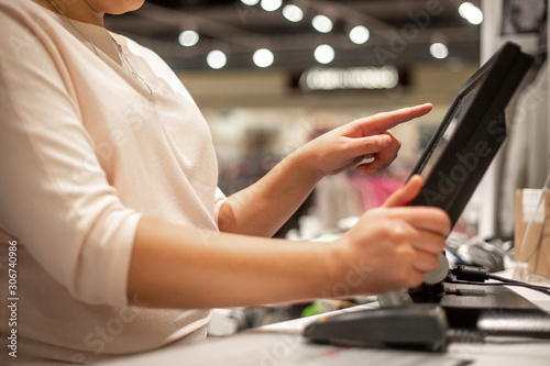 Young woman hands scaning / entering discount / sale on a receipt, touchscreen cash register, market / shop, finance concept, business