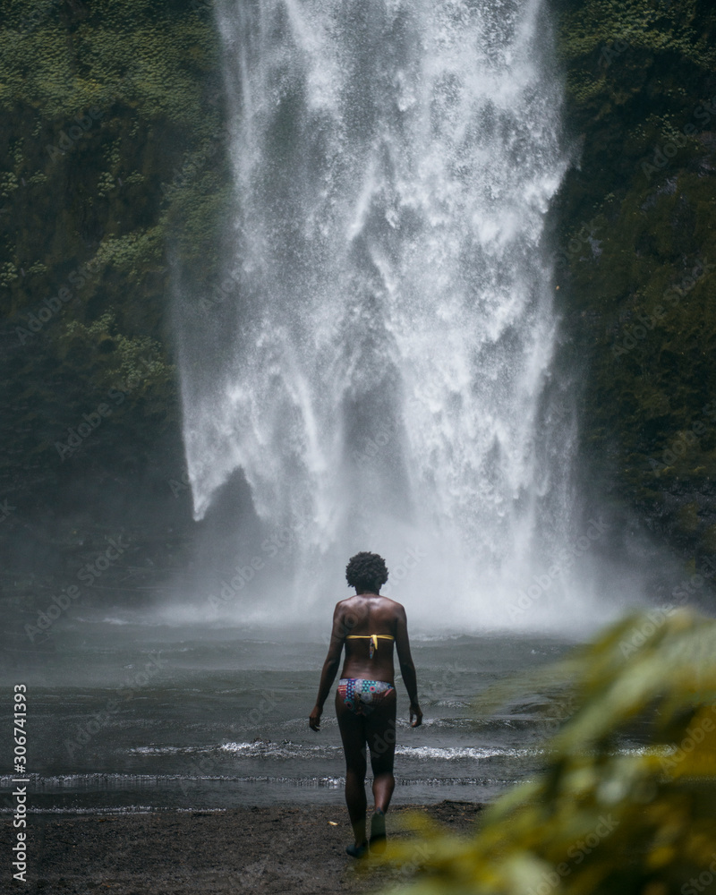 Fototapeta premium chica afro observando cascada tropical