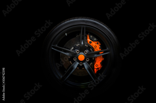 Принти на полотні Isolated generic sport car wheel with orange breaks a black background
