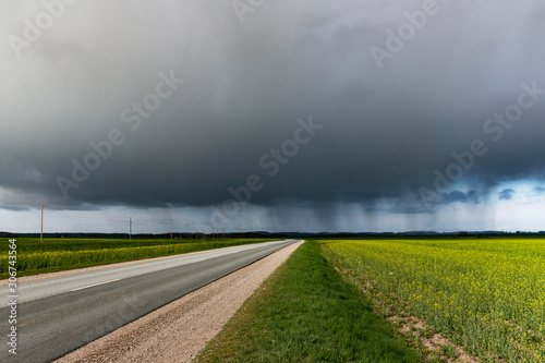 Big rain cloud and asphalt road.