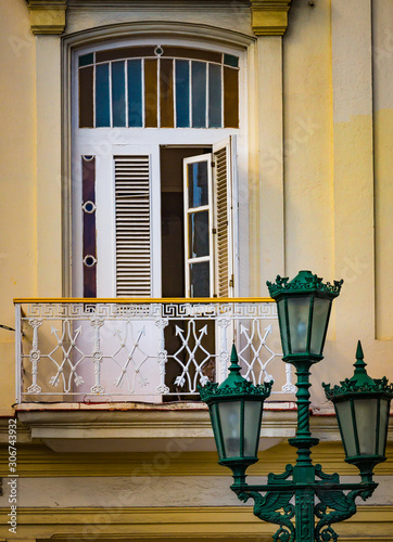 Photography Green lanterns stand before white shuttered windows in Cuba