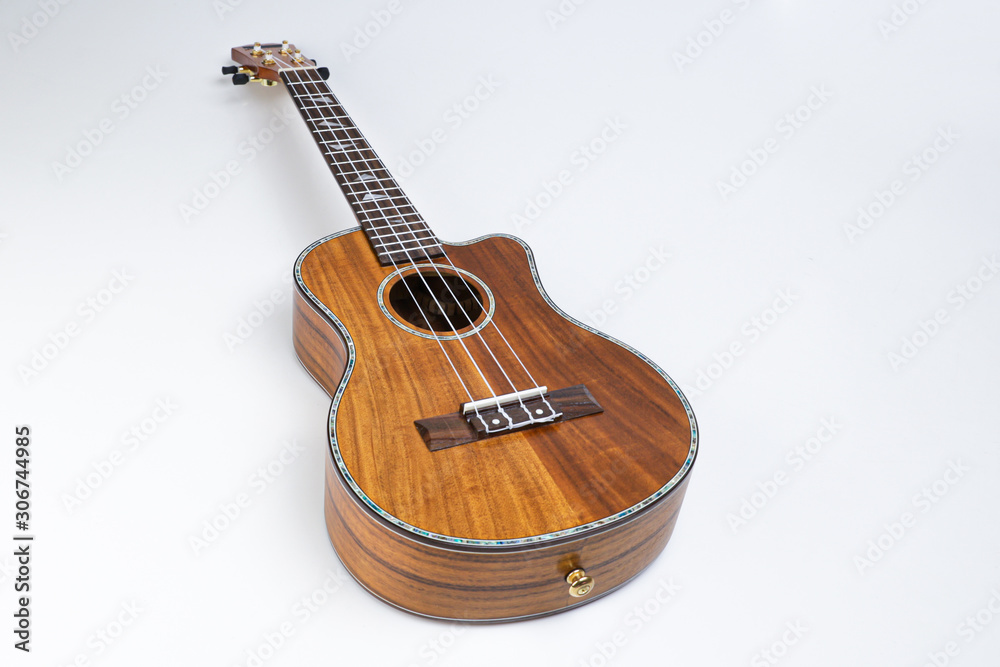 Fototapeta premium Ukulele on a white background. Hawaiian guitar lies on the table.