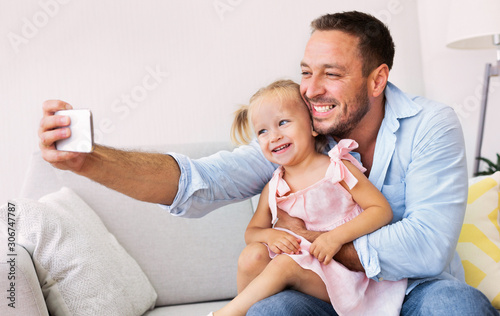 Smiling dad and little girl taking selfie photo