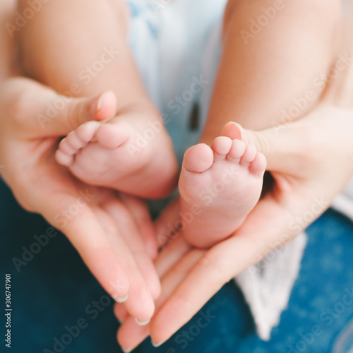 New life. Happy motherhood happiness. Mom holding baby feet.