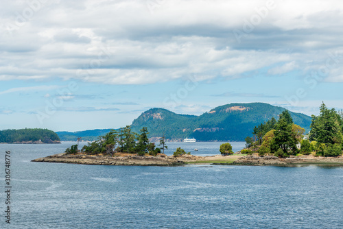 View over inlet, ocean and island with boat and mountains in beautiful British Columbia. Canada. © karamysh