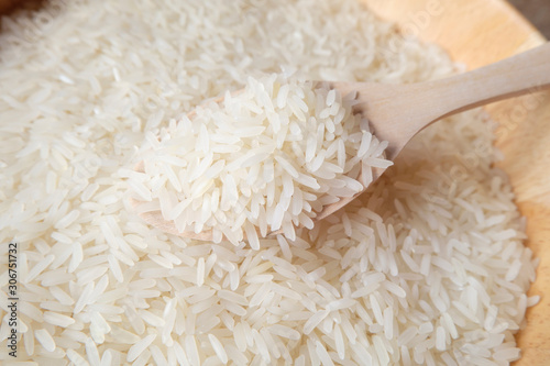 Macro shot of  rice agricultural product in wooden spoon