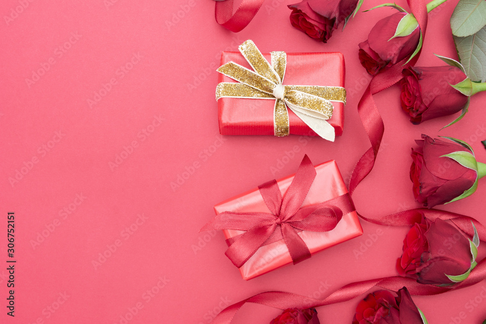 Valentine's Day, red roses and gift box with ribbon, over red background flat lay, birthday abstract background with copy space.