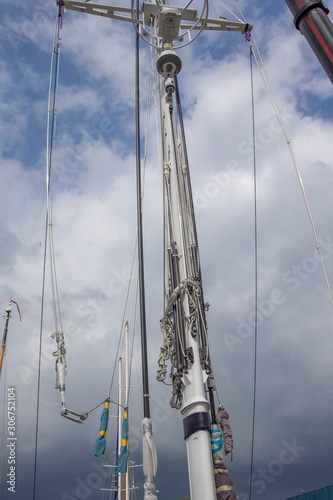 Lifting a mast with a crane. Inserting a mast on a superyacht. Shipbuilding. Shipyard. Sailing. 