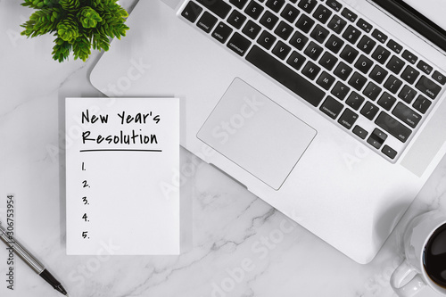 Canvas Print New Year's Resolution List on Notebook With Laptop