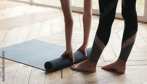 Woman rolling yoga mat, completing her practice