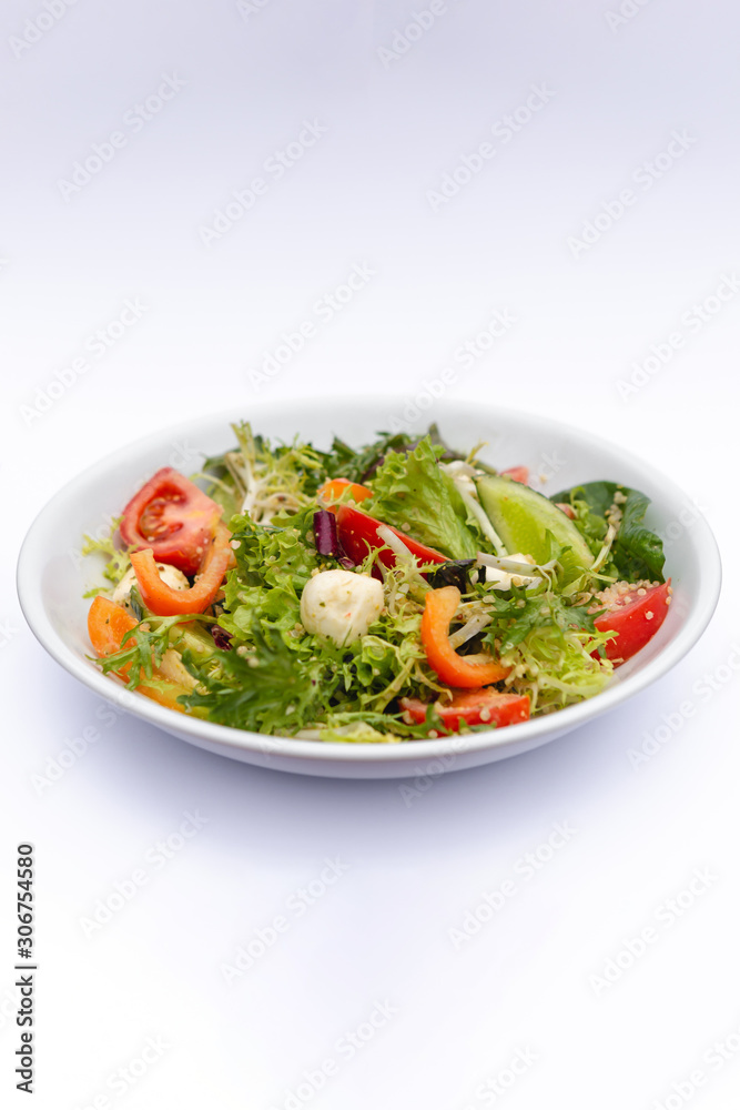 white deep plates with fresh salad ingredients mixed with sauce placed on isolated white background. A place for a menu, banner or advertisement white deep plates with fresh salad ingredients mixed with sauce placed on isolated white background. A place for a menu, banner or advertisement