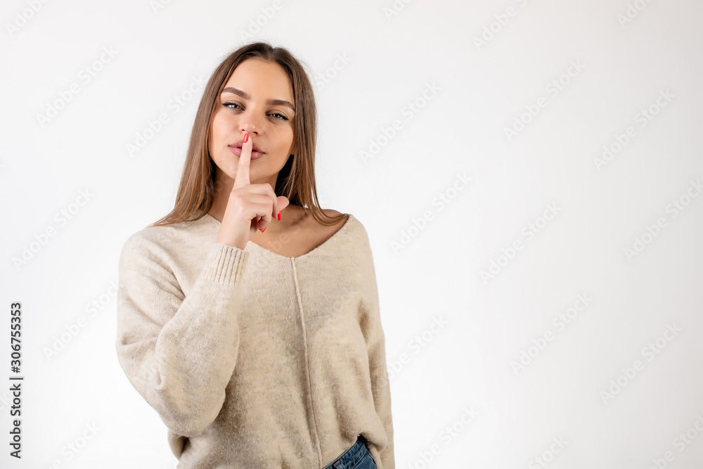 woman flirting showing silent gesture with finger close to lips isolated over white woman flirting showing silent gesture with finger close to lips isolated over white