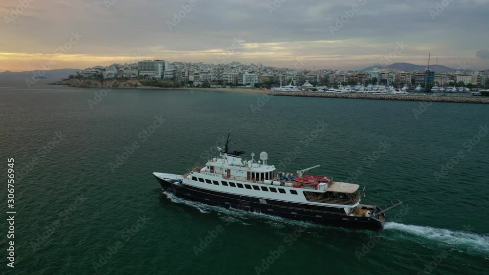 Aerial drone photo of yacht cruising leaving Marina Zeas at sunset with beautiful colours, Piraeus, Attica, Greece Aerial drone photo of yacht cruising leaving Marina Zeas at sunset with beautiful colours, Piraeus, Attica, Greece