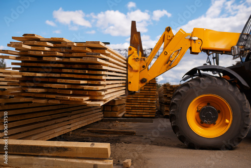 Forklift loads the boards in the lumber yard