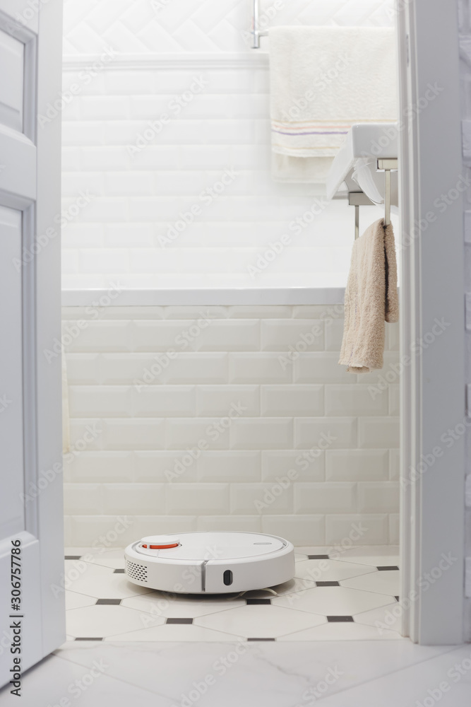 Obraz premium White robot vacuum cleaner in bathroom