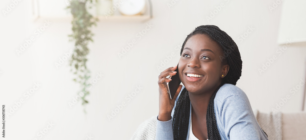 Cheerful african american girl talking on cellphone at home - obrazy, fototapety, plakaty 