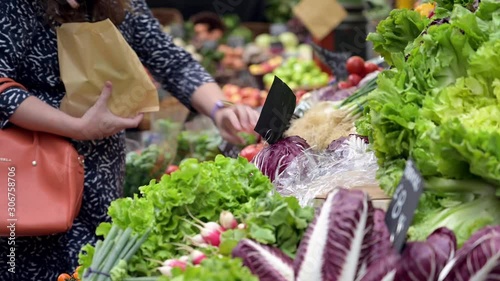 A female customer selecting vegetables at a fruit and veg stall at Borough Market, London photo