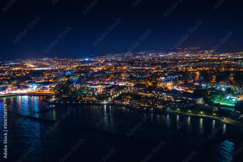 Aerial view of Paphos embankment or promenade at night with reflection of city lights in sea water. Famous Cyprus mediterranean resort.