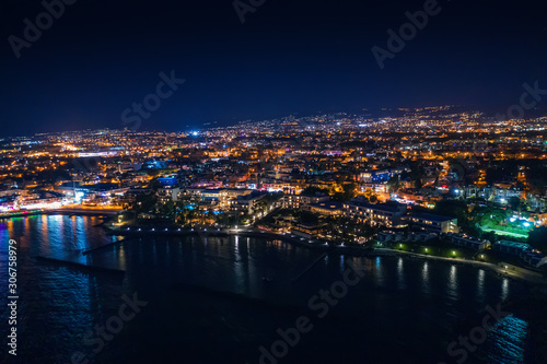 Aerial view of Paphos embankment or promenade at night with reflection of city lights in sea water. Famous Cyprus mediterranean resort.