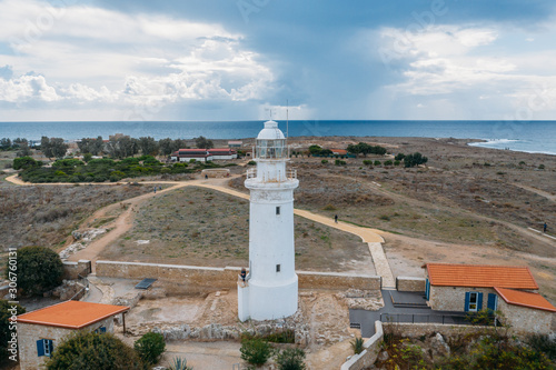 Old lighthouse on Mediterranean Sea shore in Paphos, Cyprus, aerial view from drone. Famous place in Paphos coastline.