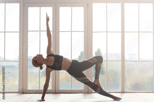 Fototapeta Naklejka Na Ścianę i Meble -  Young lady demonstrating beautiful strong body at yoga studio