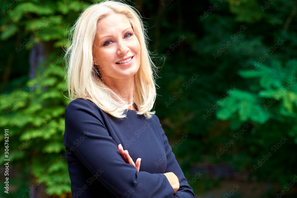 Happy blond woman wearing black dress while standing outdoor Happy blond woman wearing black dress while standing outdoor