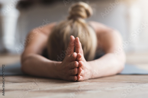 Woman laying face down on yoga mat, meditating photo