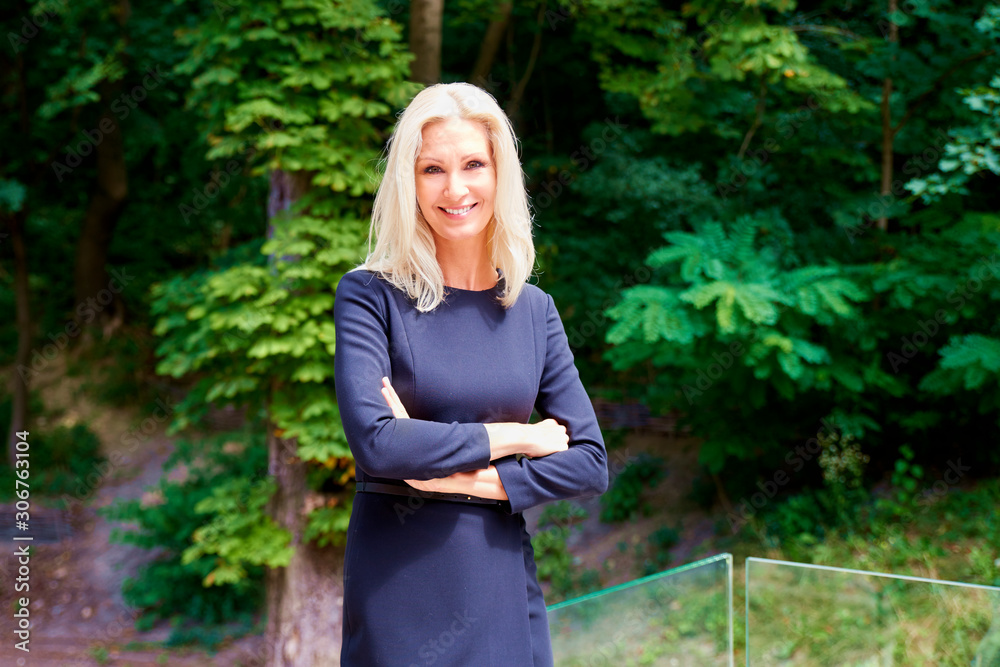 Happy blond woman wearing black dress while standing outdoor Happy blond woman wearing black dress while standing outdoor