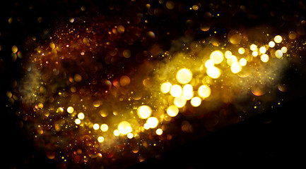 Golden Christmas and New Year glittering stars swirl on black bokeh background, backdrop with sparkling golden stars, holiday garland, magic glowing dust, lights. Gold Abstract Glitter Blinking sparks