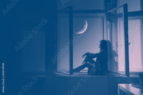 Fotografie Woman sitting at the window looking at stars and the moon, Artistic Photography