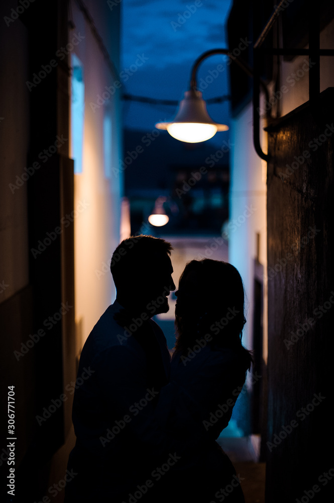 Young romantic married couple stading in the side street under the lantern