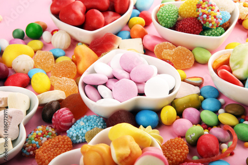 candies with jelly and sugar. colorful array of different childs sweets and treats on pink background © beats_