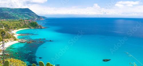Fototapeta Naklejka Na Ścianę i Meble -  Aerial amazing tropical panoramic view of turquoise gulf bay, sandy beach, green mountains and plants, blue sky white clouds background, cliffs platform Cape Capo Vaticano, Calabria, Southern Italy