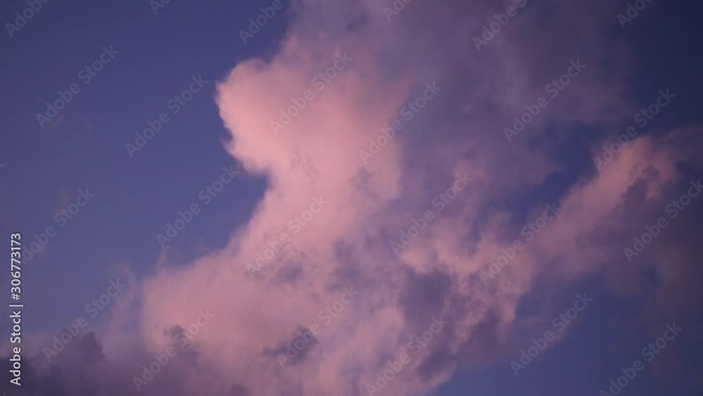 White-pink clouds on the evening blue sky. Pink clouds at sunset. White-pink clouds on the evening blue sky. Pink clouds at sunset.