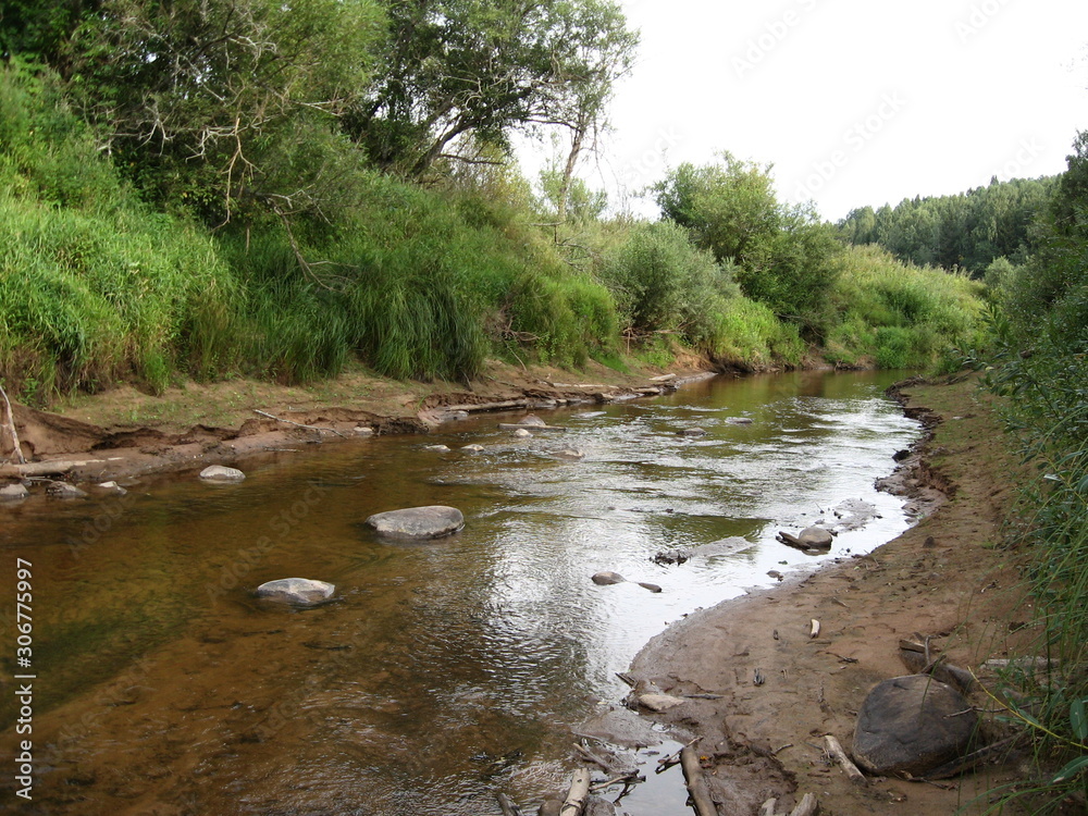 Summer landscape with a small river in the forest with river rolling, sandy beach, granite stones, bushes and grass. Summer landscape with a small river in the forest with river rolling, sandy beach, granite stones, bushes and grass.